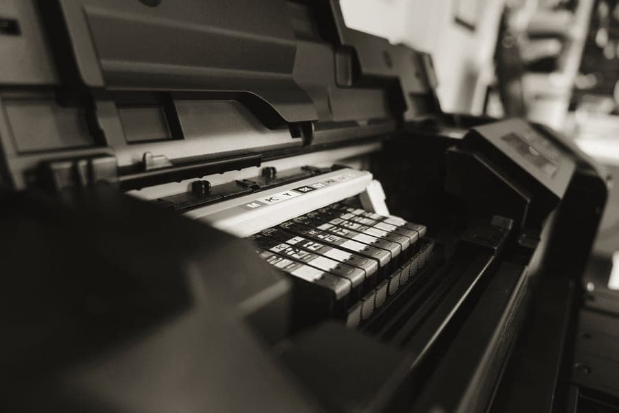 A compact desktop photo printer producing a 4 x 6 print