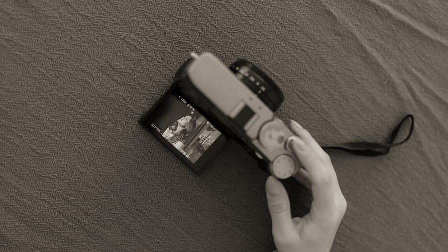 A hybrid instant camera with a rear screen showing a photograph before printing