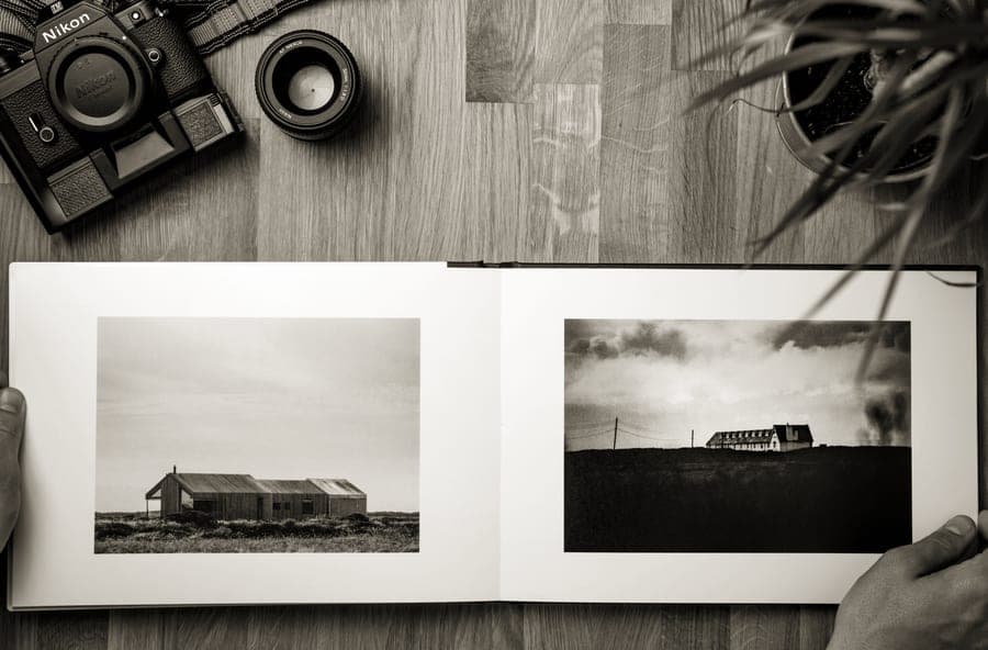 An open photo album with instant prints slotted into pocket pages