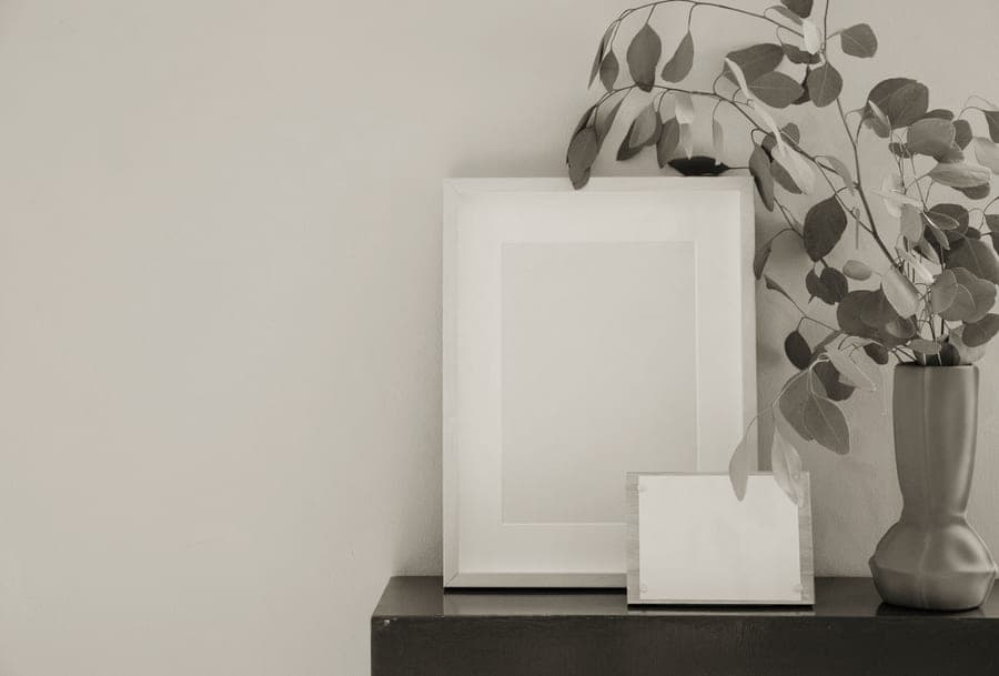 Small clear photo frames holding instant prints on a shelf