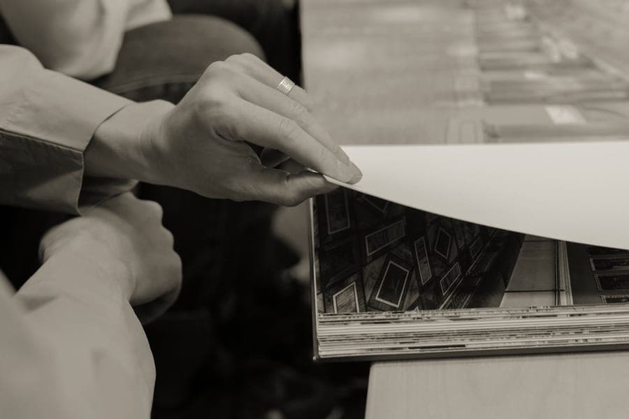 A small pocket photo album held in one hand, prints visible inside