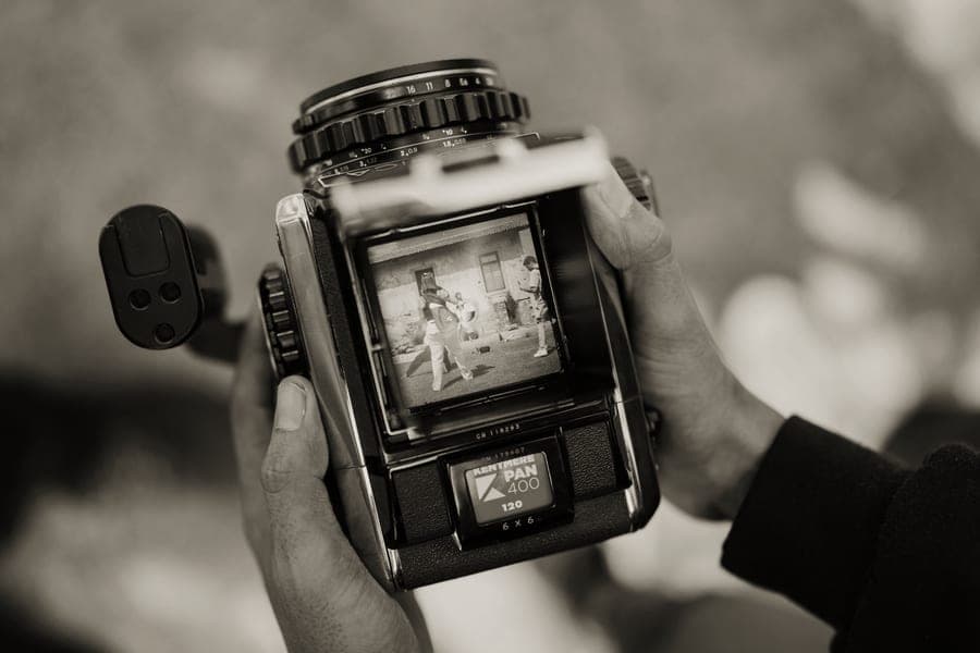 A larger wide-format instant camera held in two hands