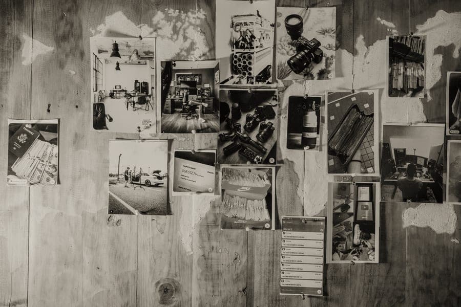 Instant prints in a sleeved album beside framed prints on a shelf