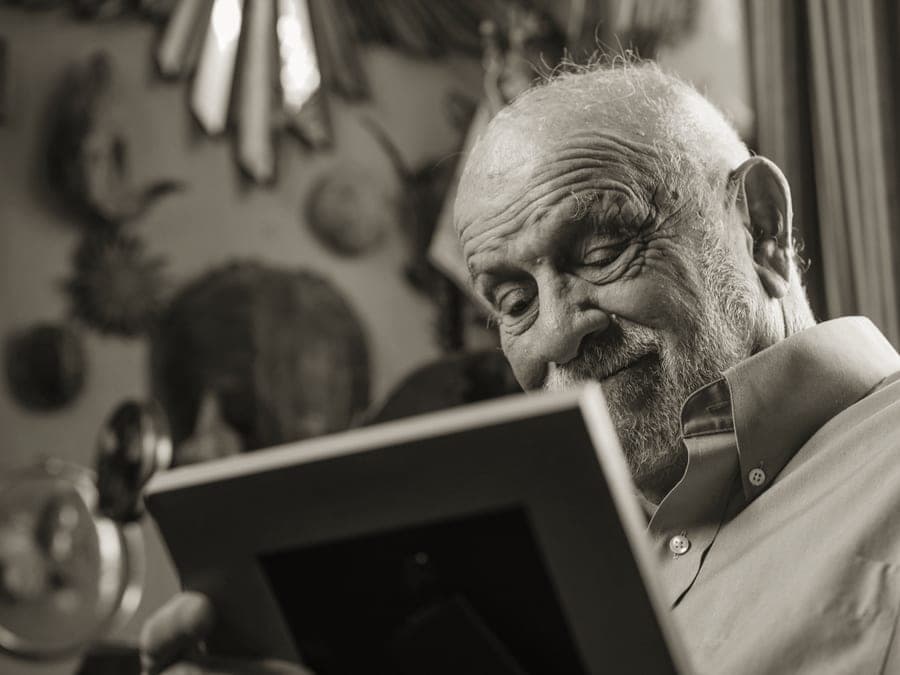 Two older people looking through a set of printed photographs together