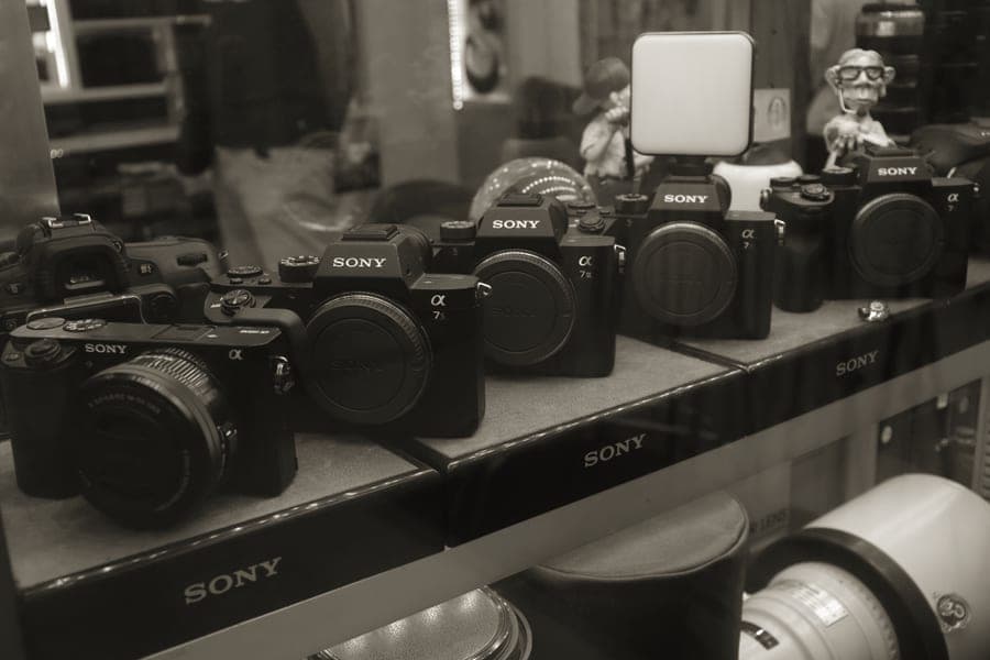 A shelf of instant cameras and film packs in a camera shop