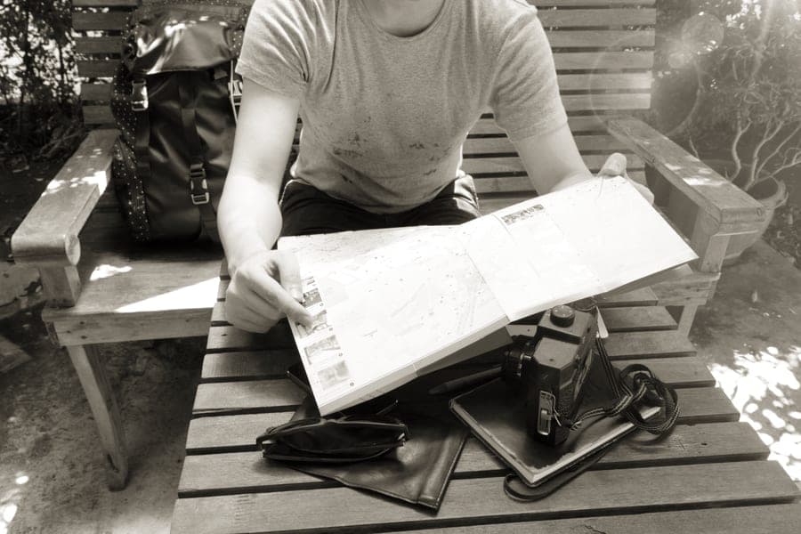 A backpack, map and camera laid out for a trip